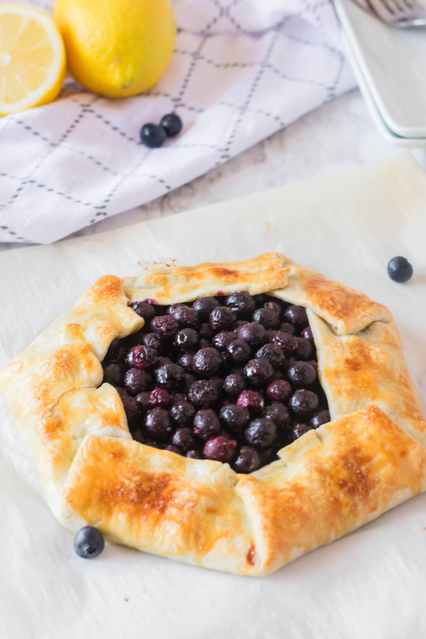A rustic blueberry tart full of fresh berries wrapped in a pie crust.