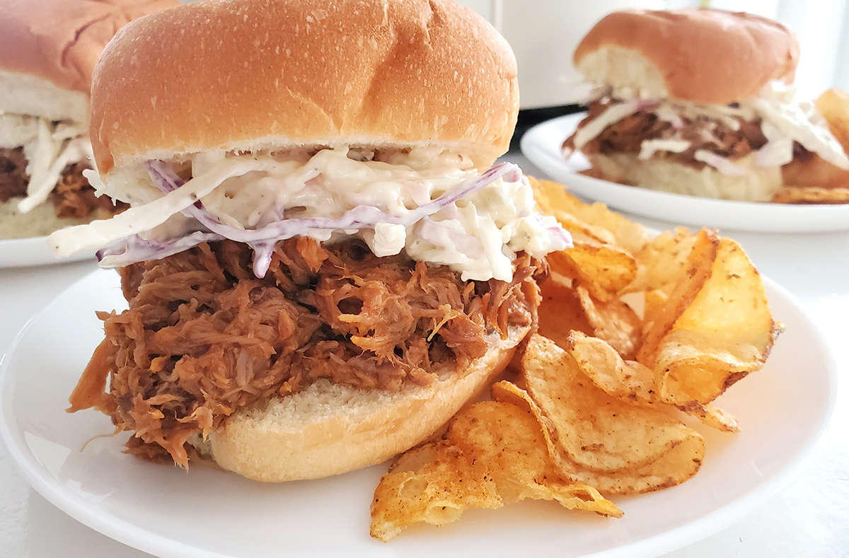 Shredded pork sandwich with coleslaw and chips